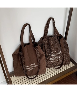 Detalle de bolsos tote de pana marrón y estampado de leopardo con diseño de letras