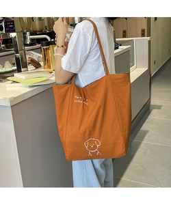 Détail du sac fourre-tout en toile orange avec illustration de chiot blanc et texte