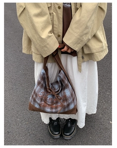 Close-up of vintage plaid tote bag with artistic embroidery and cord bow detail
