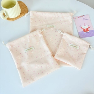 Detailed set of three pink corduroy drawstring storage bags with cute rabbit patterns
