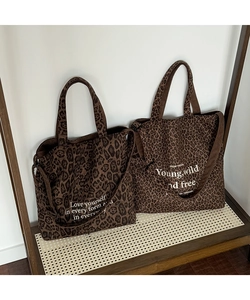 Detalle del bolso tote de lona con estampado de leopardo y asas de pana con texto motivador