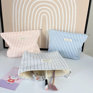 Three pleated striped fabric makeup bags in pink, blue, and grey with a large capacity