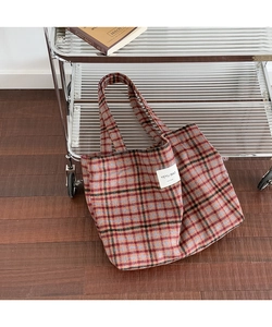 Detail shot of vintage plaid tote bag with heavy fabric texture and woven shoulder strap