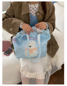 Detail of light blue polka dot tote bag with 3D teddy bear and drawstring closure