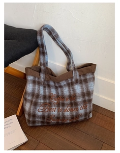 Detail of wool plaid tote bag with brown corduroy trim and embroidered coffee quote