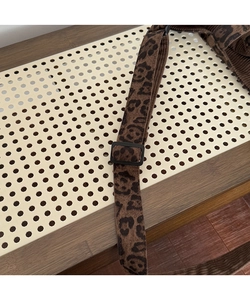 Detalle de la correa ajustable en el bolso tote de pana con estampado de leopardo y hebilla