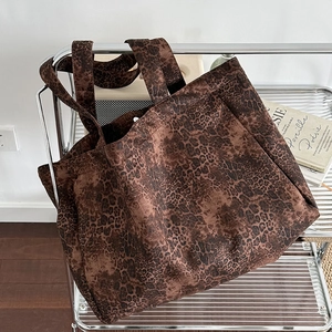 Stylish leopard print canvas tote bag with large capacity hanging on a metal rack
