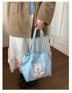 Close-up of cute 3D plush puppy embroidery and Lucky Puppy text on light blue tote bag