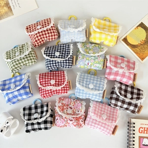 Detail of floral and plaid earbud cases with lace trim and colorful hanging hooks