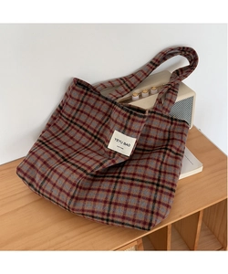 Detail of vintage plaid tote bag with woven fabric texture and stitched brand label