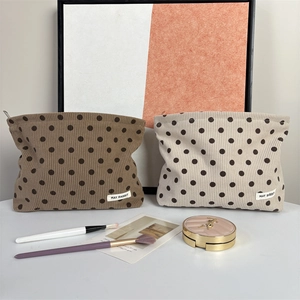 Detailed close-up of corduroy polka dot makeup bags with secure metal zipper closure