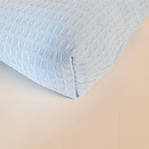 Detailed close-up of light blue waffle weave fabric with soft texture and neat stitching