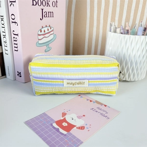 Detailed view of the pleated striped fabric texture and silver zipper pull on the pencil case