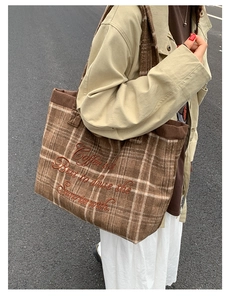 Detailed close-up of brown plaid wool tote bag with corduroy trim and embroidery