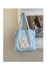 Detail of light blue polka dot tote bag with puppy embroidery and Lucky puppy text