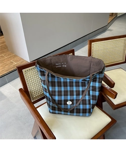 Détail du sac cabas en toile à carreaux bleu et beige avec doublure et logo en texte