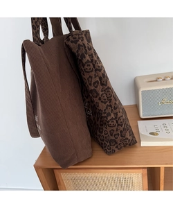 Primer plano detallado de bolsos tote de pana marrón y estampado de leopardo bordados