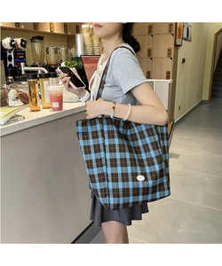Grand sac cabas en toile à carreaux bleu et marron présenté dans un style de vie urbain