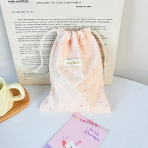 Close-up of pink corduroy storage bag with cute rabbit prints and drawstring closure