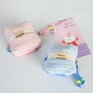 Detail view of mini woven tweed earphone case with colorful beads and mayrabbit label