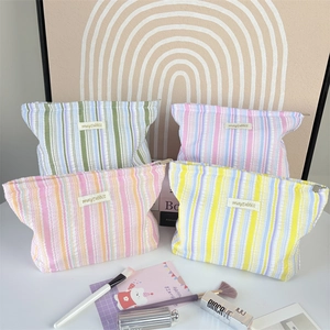 Set of four striped cosmetic bags in pastel colors with macro texture and zippers