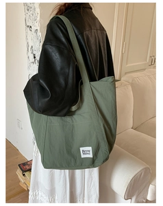 Detail of army green nylon tote bag with white Beyou Merci fabric label on front