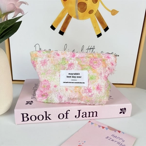 Macro detail of pink floral chiffon cosmetic bag with soft texture and chic brand label