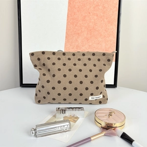 Detail of vintage corduroy polka dot makeup bag with brand label and sturdy zipper texture