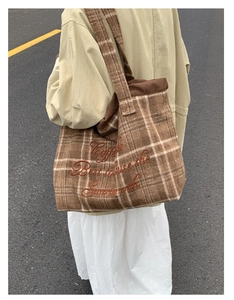 Detail of brown plaid tote bag with vintage embroidery on wool fabric and wide strap