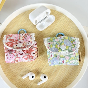 Floral fabric earphone cases with lace trim and blue hooks in a wooden tray