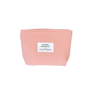 Pink waffle texture cosmetic bag with minimalist label and compact square design