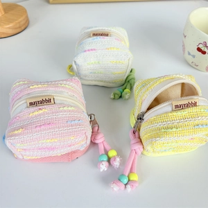 Mini tweed earphone pouches in pink, yellow, and white with cotton rope accents