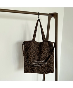 Detalle del bolso tote de lona leopardo con correa extraíble y frase inspiradora