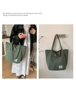 Detail of dark green nylon tote bag featuring side pocket and white brand label
