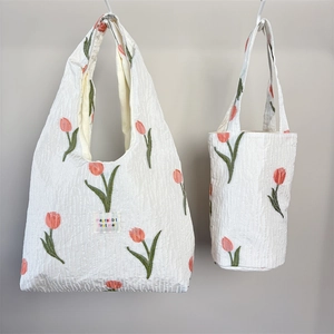 Detail von gesteppter Tragetasche und Eimertasche mit Tulpenstickerei im Set-Design