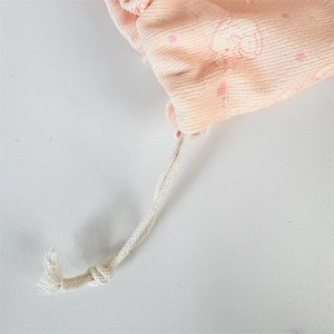 Close-up of pink corduroy drawstring bag with cute rabbit prints and cotton ropes