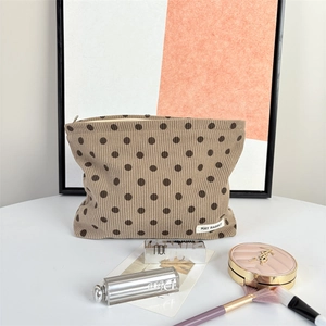 Detailed texture of brown polka dot corduroy makeup bag with secure zip closure