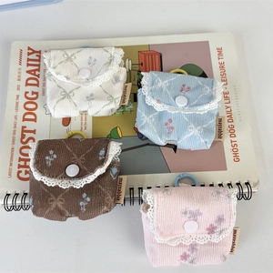 Close-up of corduroy storage pouches with lace trim and snap button closure in various colors