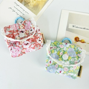 Close-up of floral earphone pouch with delicate lace trim and blue hanging hook