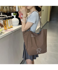 Détail d'un grand sac cabas en toile marron avec chien de dessin animé et doublure à carreaux