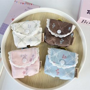 Detailed view of corduroy earphone pouches with lace trim and floral patterns