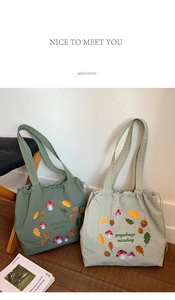 Detail of mushroom embroidery on nylon tote bags in dark and light green shades