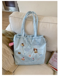 Close-up of cute cartoon puppy embroidery and polka dots on light blue drawstring tote bag