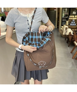 Détail du sac cabas marron avec dessin de chiot et doublure intérieure à carreaux bleus