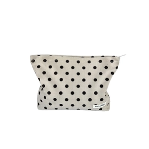 Beige corduroy polka dot makeup bag with zipper closure and white brand label