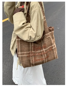 Close-up of brown plaid wool tote bag featuring vintage embroidery and corduroy texture