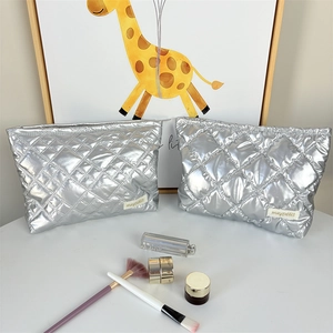 Detail of silver quilted makeup bag with metallic finish and smooth zipper closure