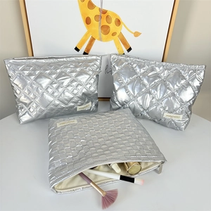 Three-piece silver quilted makeup bag set with metallic finish and spacious storage capacity