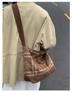 Outdoor shot of a brown plaid corduroy shoulder bag showing fabric texture and drape