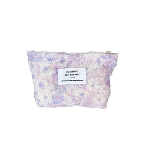 Purple floral plush makeup bag with soft velvet texture and white woven label